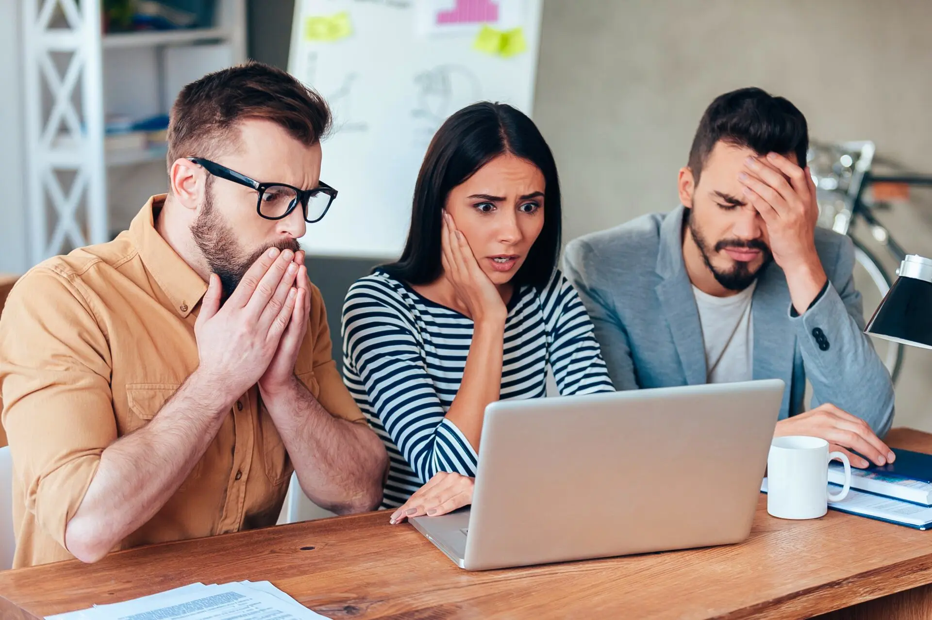 Zabrinut tim gleda u laptop zbog problema na web stranici ili kampanji